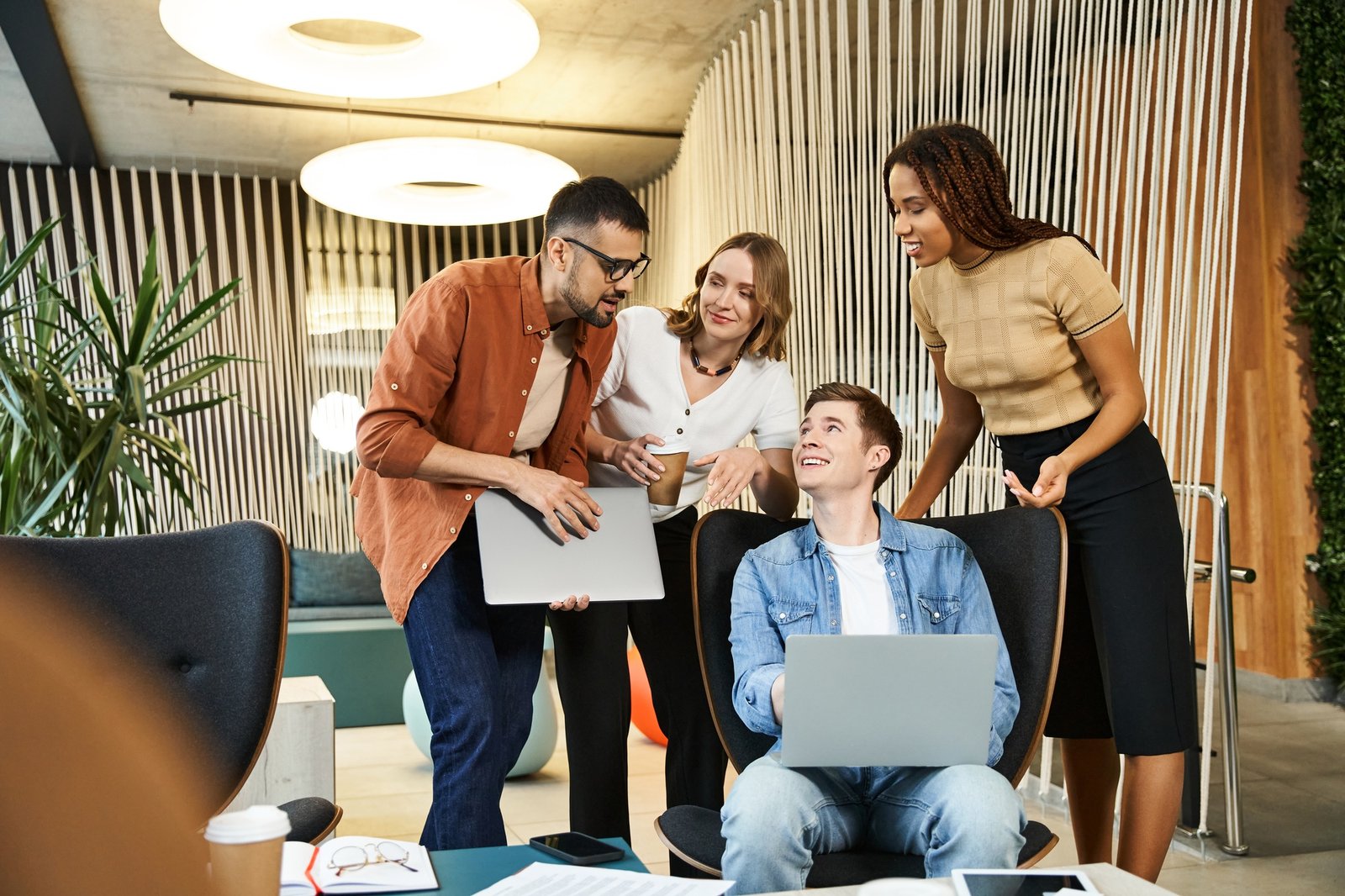 Collaboration about tech news: team huddle around laptop
